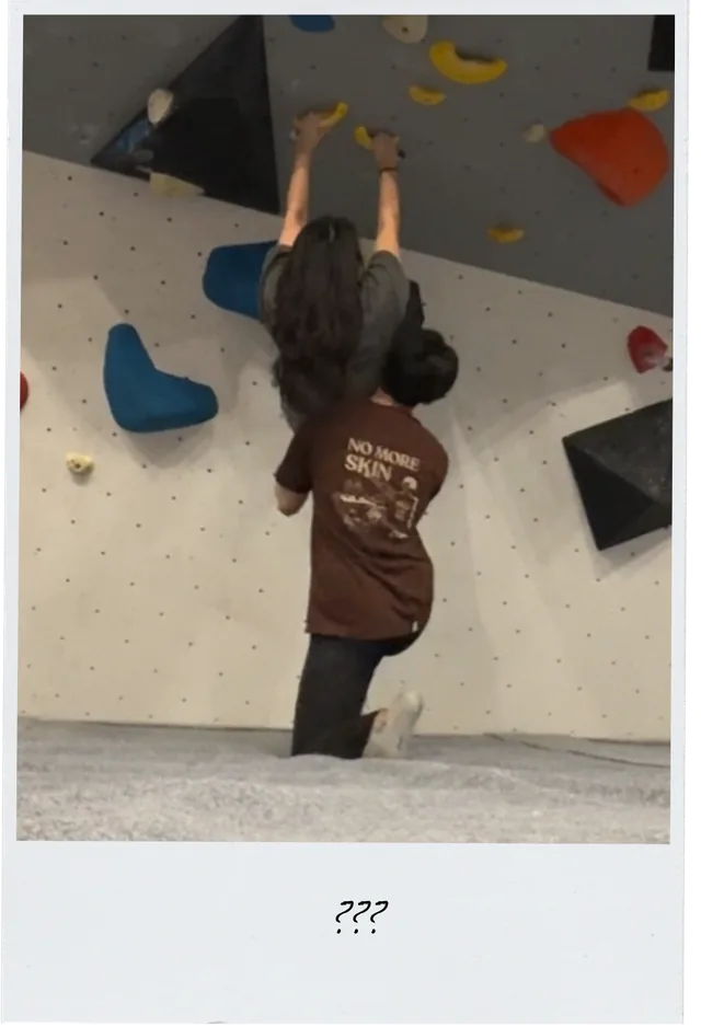 A playful moment at the climbing gym, captioned ???